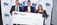 Three people stand in front of an ABC of Iowa backdrop holding an oversized $1,000 check made out to Rock Valley Community School District.