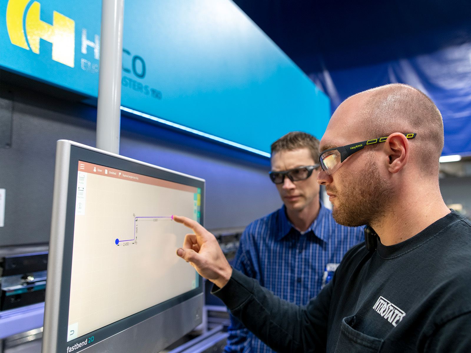 Two Interstates employees look at a screen and point.