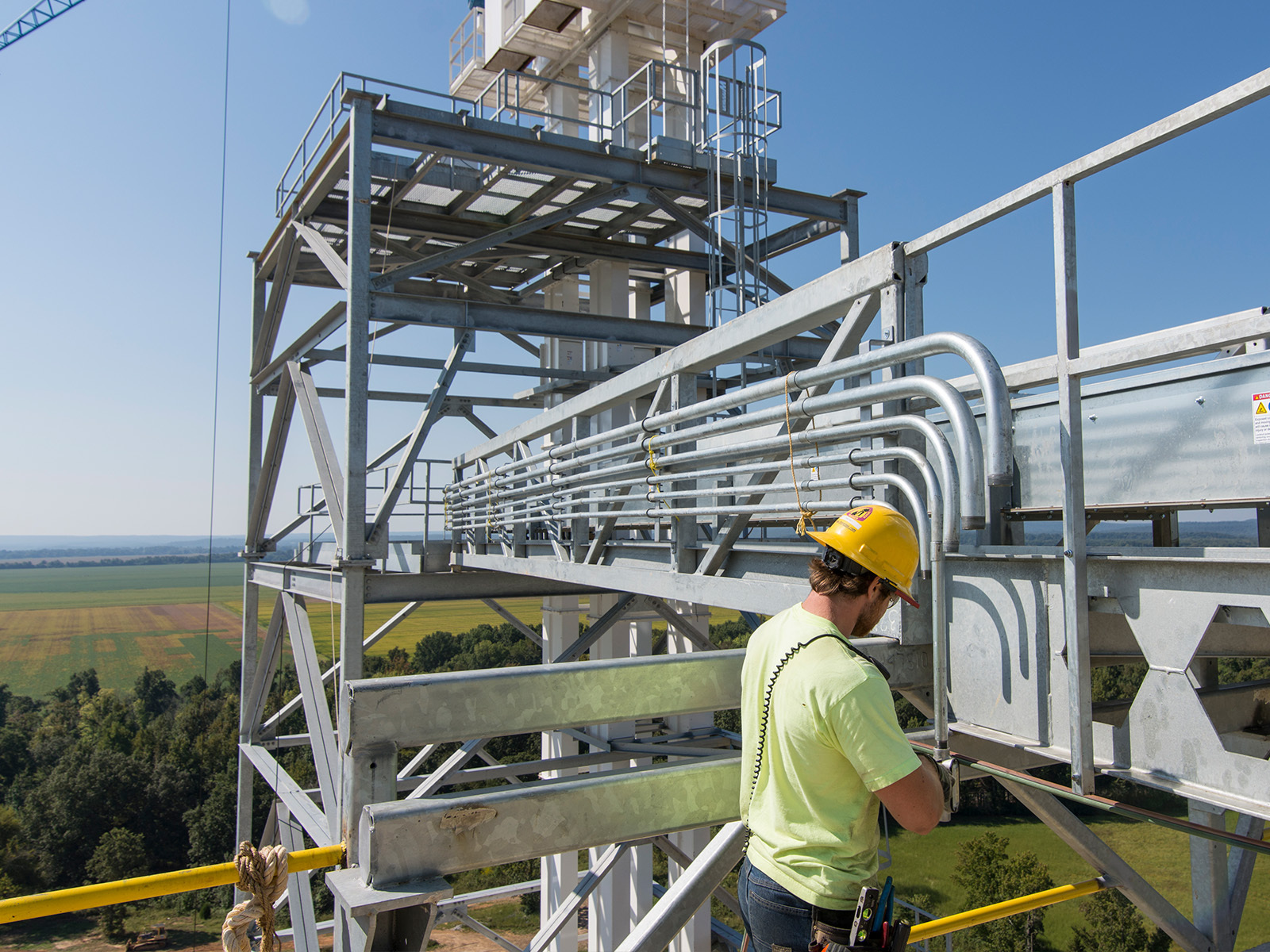 An electrician works at a high elevation.