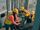 Three people working on laptops in an industrial facility. They're wearing proper PPE and working in a panel.