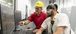Two men working and pointing at a computer.