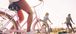 Three people smiling and riding bike.