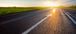 Arrow pointing down a highway towards a sunset.