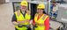 Two women smiling wearing PPE gear.