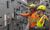 Two men wearing PPE in an electric room.