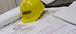 A yellow Interstates branded hard hat sitting on top of blueprint plans.