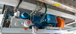 A close-up view of an industrial setup featuring a blue electric motor, hydraulic components, and electrical wiring.
