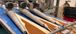Close-up of a food processing machine shaping layered dough with filling on a conveyor belt in a production facility.