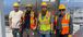 Four of our craft team members in front of a PLC panel.