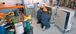 Two people in arc flash suits kneeling to look into electrical boxes.