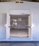 Interior of a modular electrical building with white walls, floor openings for equipment installation, and double doors at the far end.