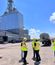 Five people standing outside of a facility in construction gear.