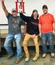 Three people excitedly holding a trophy