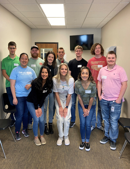 A diverse group of interns smiling and posing for a group photo