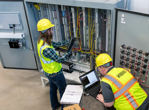 Two system analysts monitoring the networking devices in a control panel.