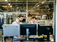 Two employees looking at several monitors in an industrial facility.