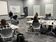 Several people in a conference room listening to a speaker.