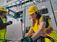 Two people working in an industrial environment in a panel and on a laptop