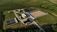 Aerial view of a modern wastewater treatment facility surrounded by green fields.