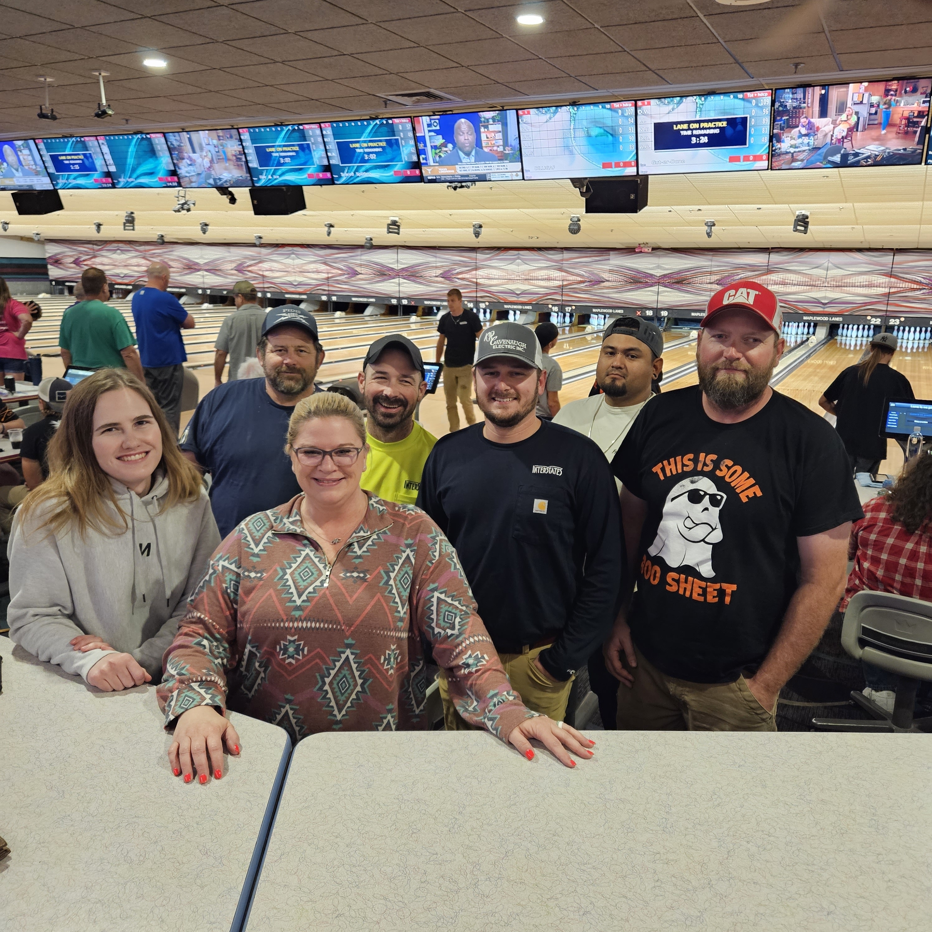 A team in a bowling alley smiling