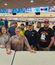 A team in a bowling alley smiling