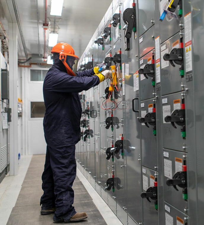 Employee in working on energized equipment with full PPE gear on.