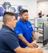 An Interstates employee helps another employee on a computer.