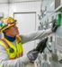 Electrician looking at equipment holding an iPad monitoring the electrical system.