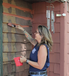 Woman painting a house.
