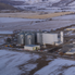 Aerial view of a flour mill in Utah. There is snow on the ground and mountains in the background.