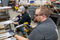 Two men with safety glasses and gloves working in a manufacturing shop making prefabricated conduit.