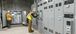 two men in PPE working in an electric room