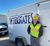 Electrician in high-visibility safety gear standing beside an Interstates trailer.