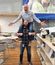 Playful office moment with one employee sitting on another's shoulders in break room, surrounded by modern décor and company branding